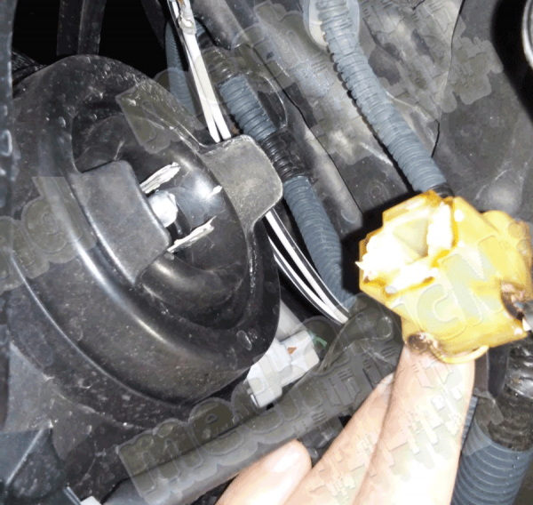 Figura 2: si vede il connettore rimosso e le 2 linguette della cuffia in gomma nera